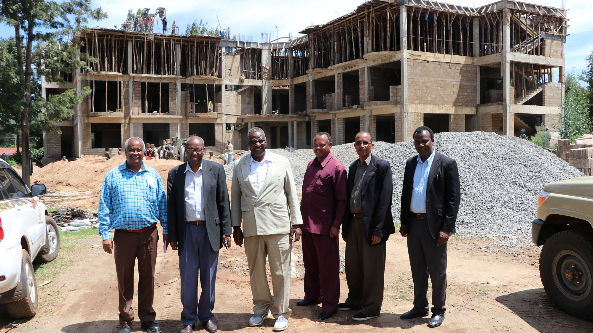 Kirkeledere foran byggeplass med stort nybygg
