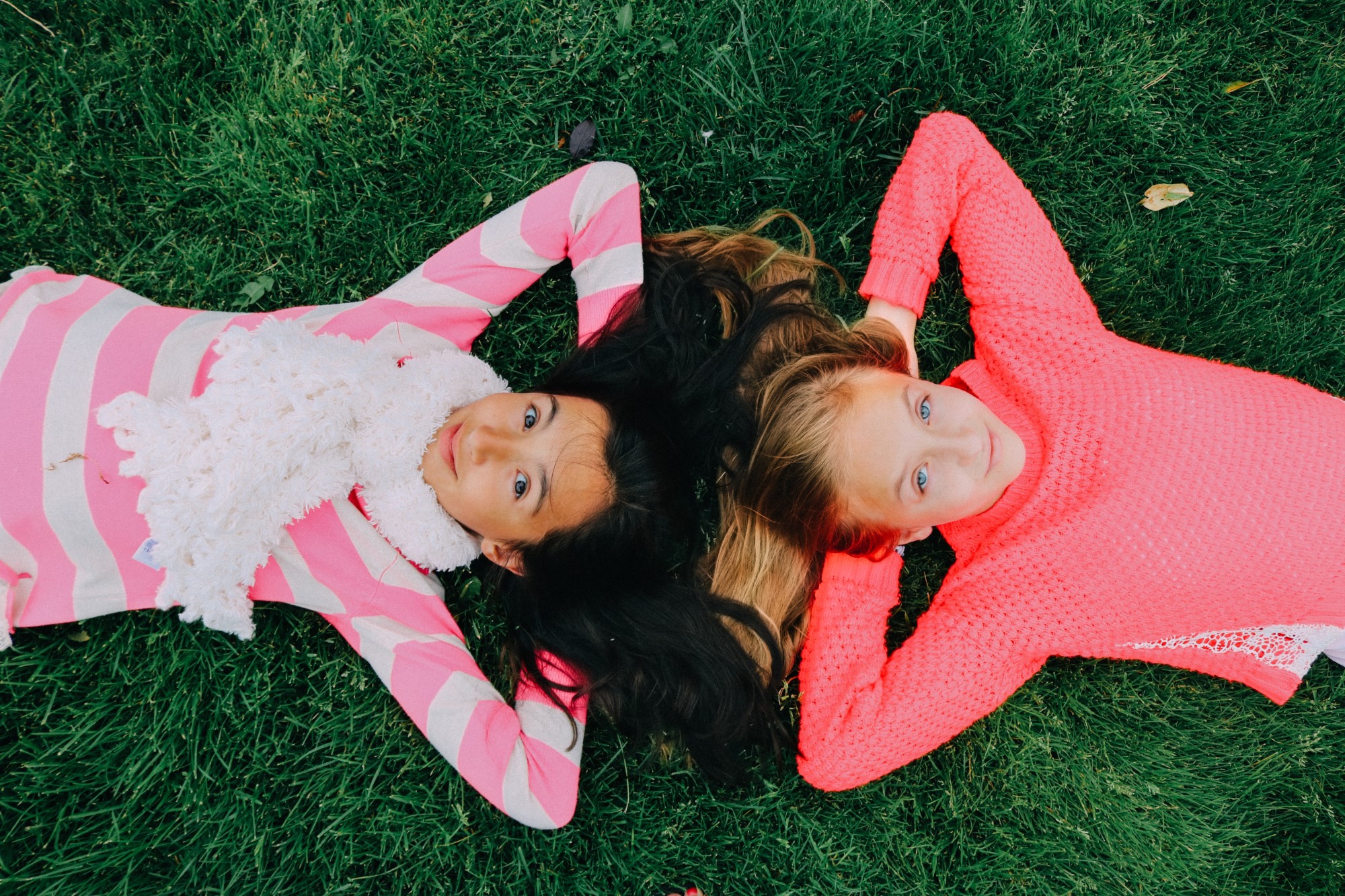 To jenter ligger i gresset