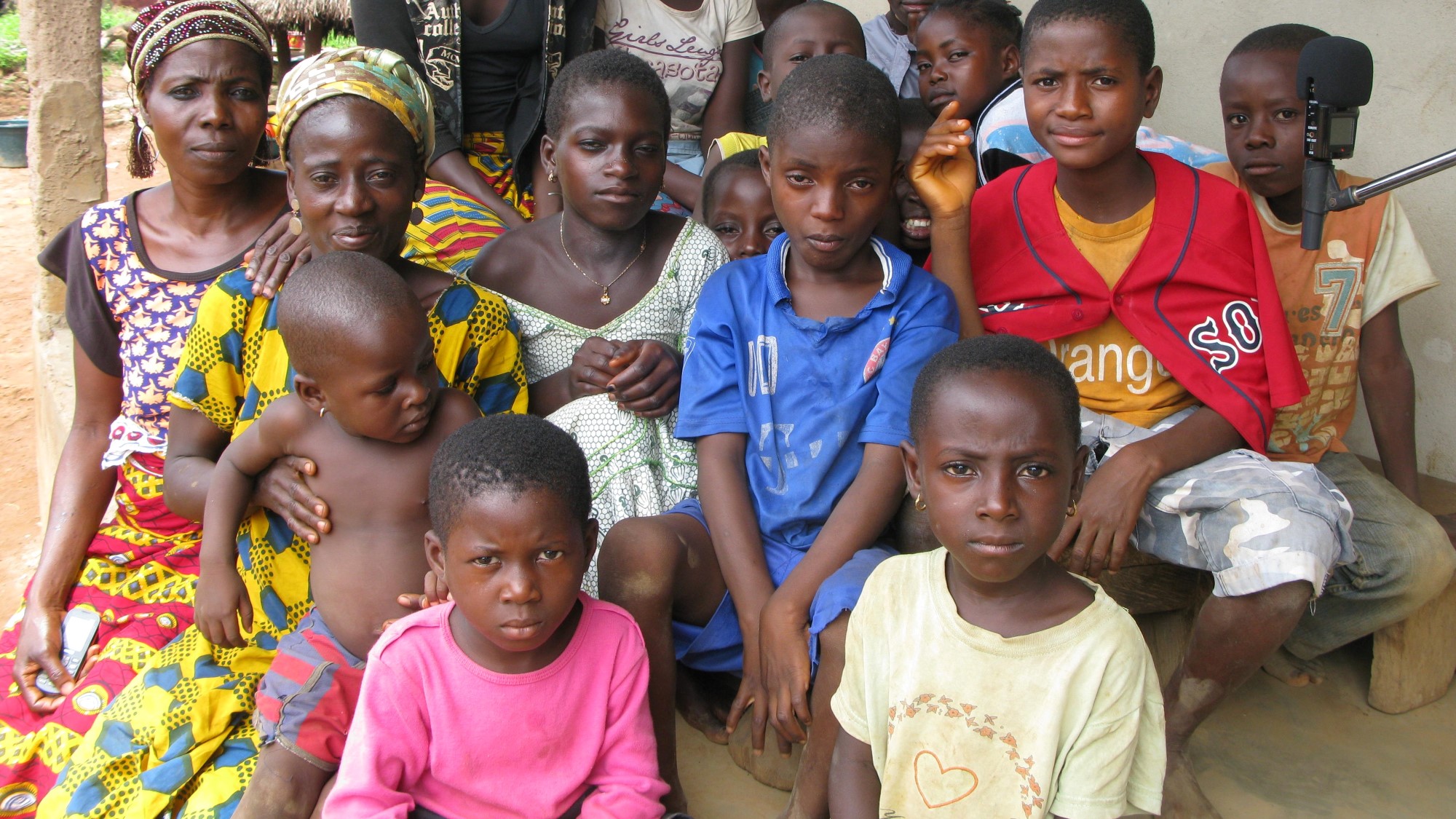 En flokk med barn, unge og to voksne damer fra Elfenbenskysten