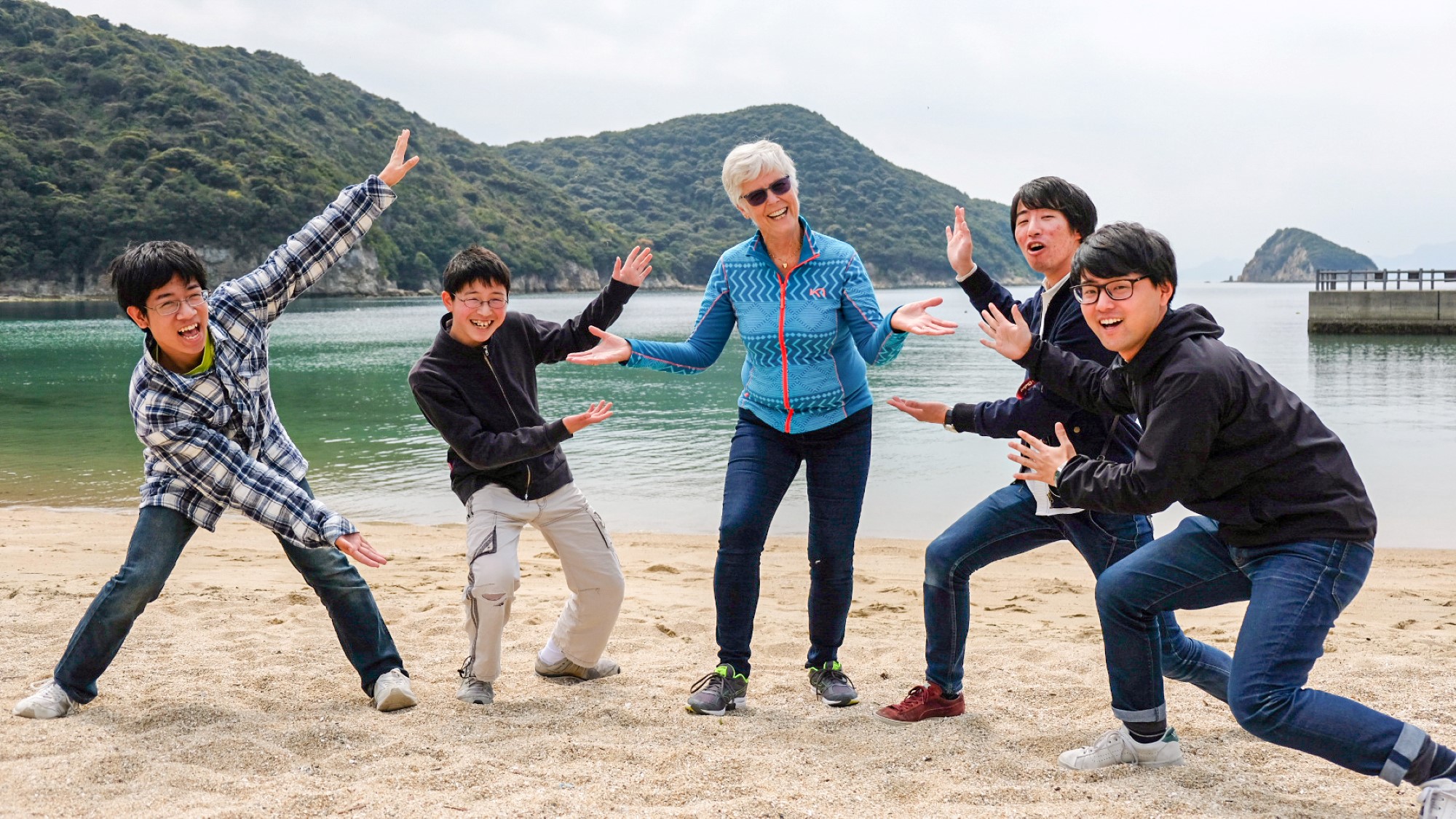 Kari Opperud og fire japanske ungdommer poserer på strand