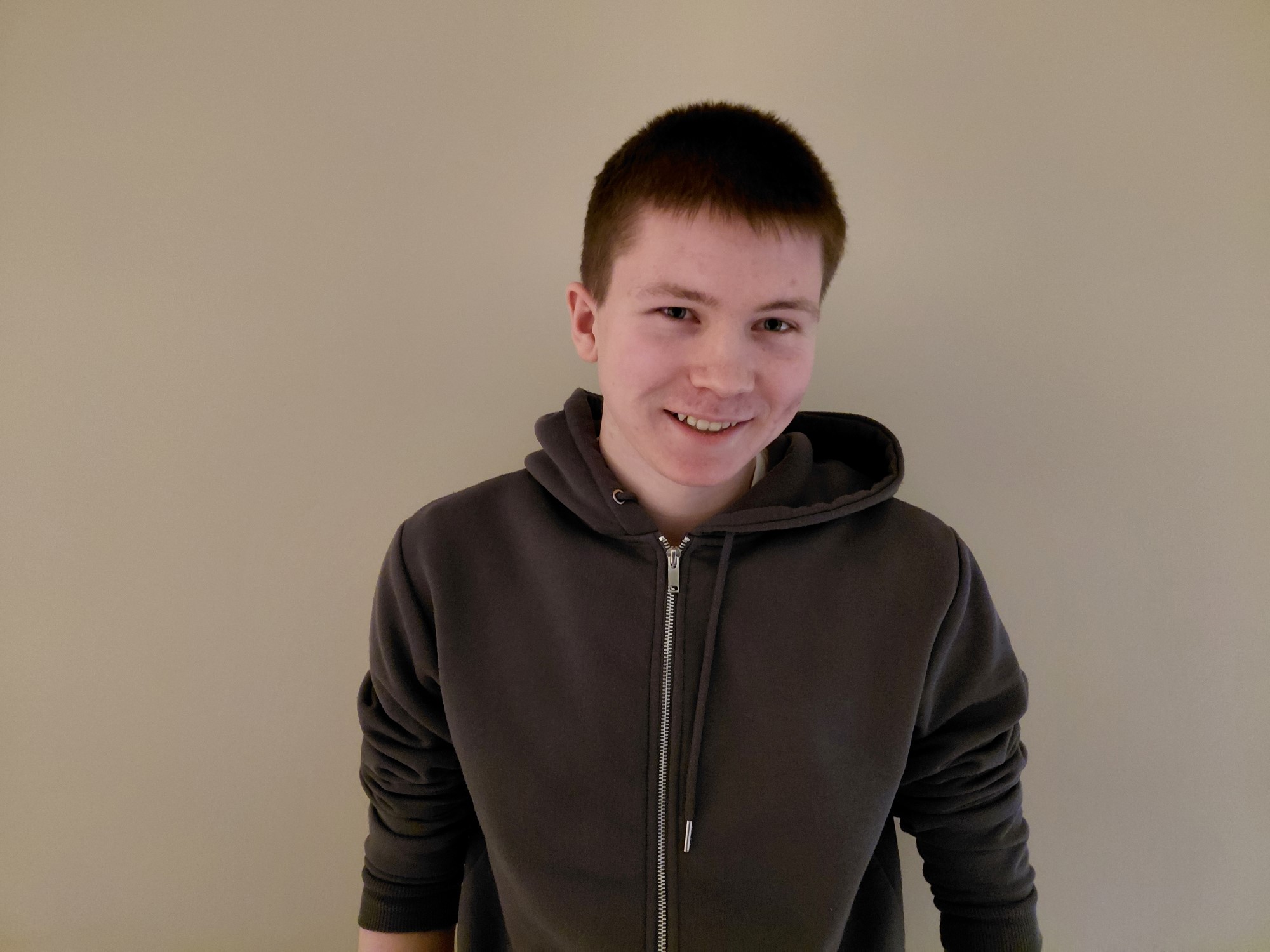 Bildet viser en smilende ung mann