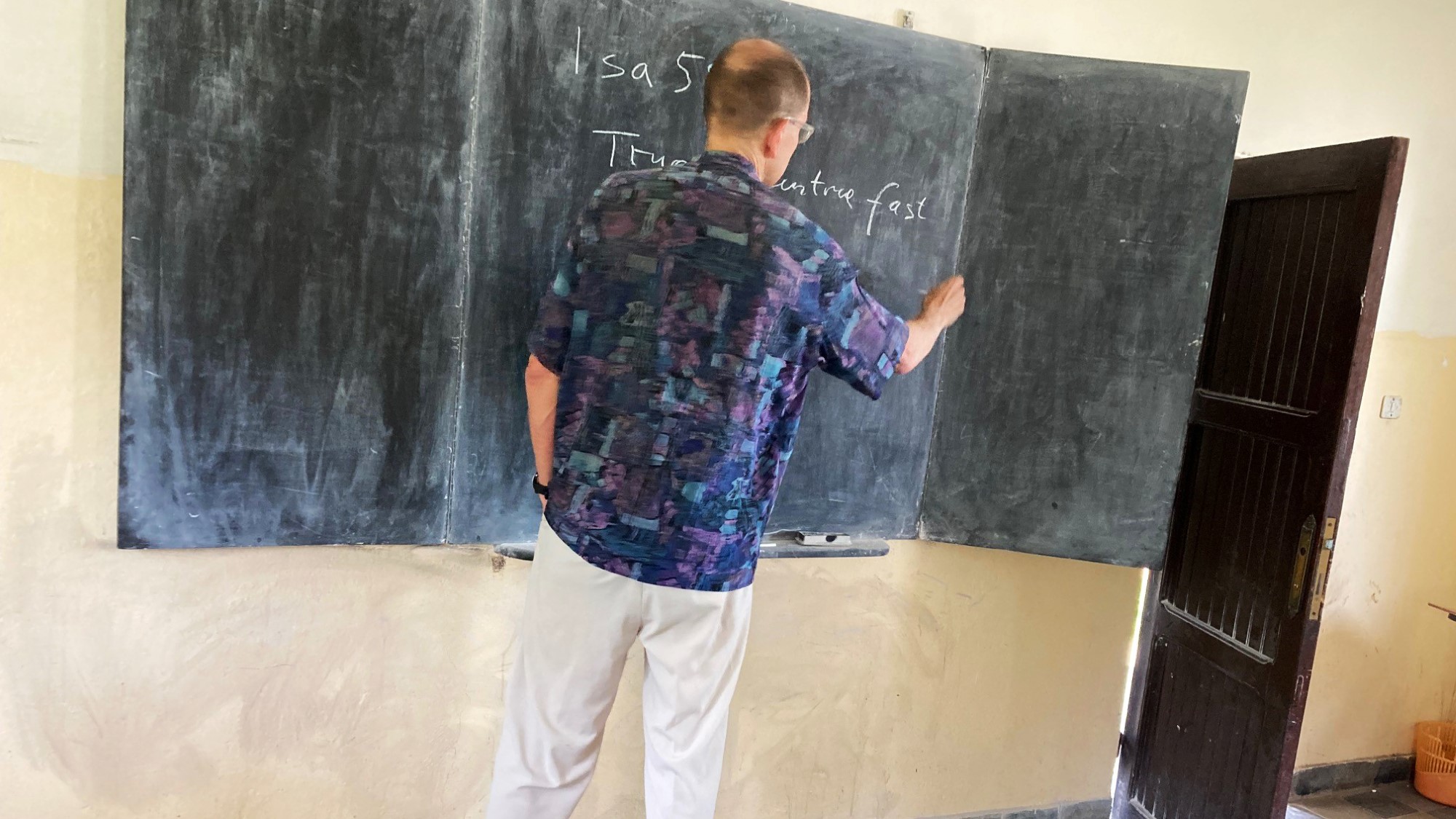 Magnus Riska skriver på tavle i klasserom