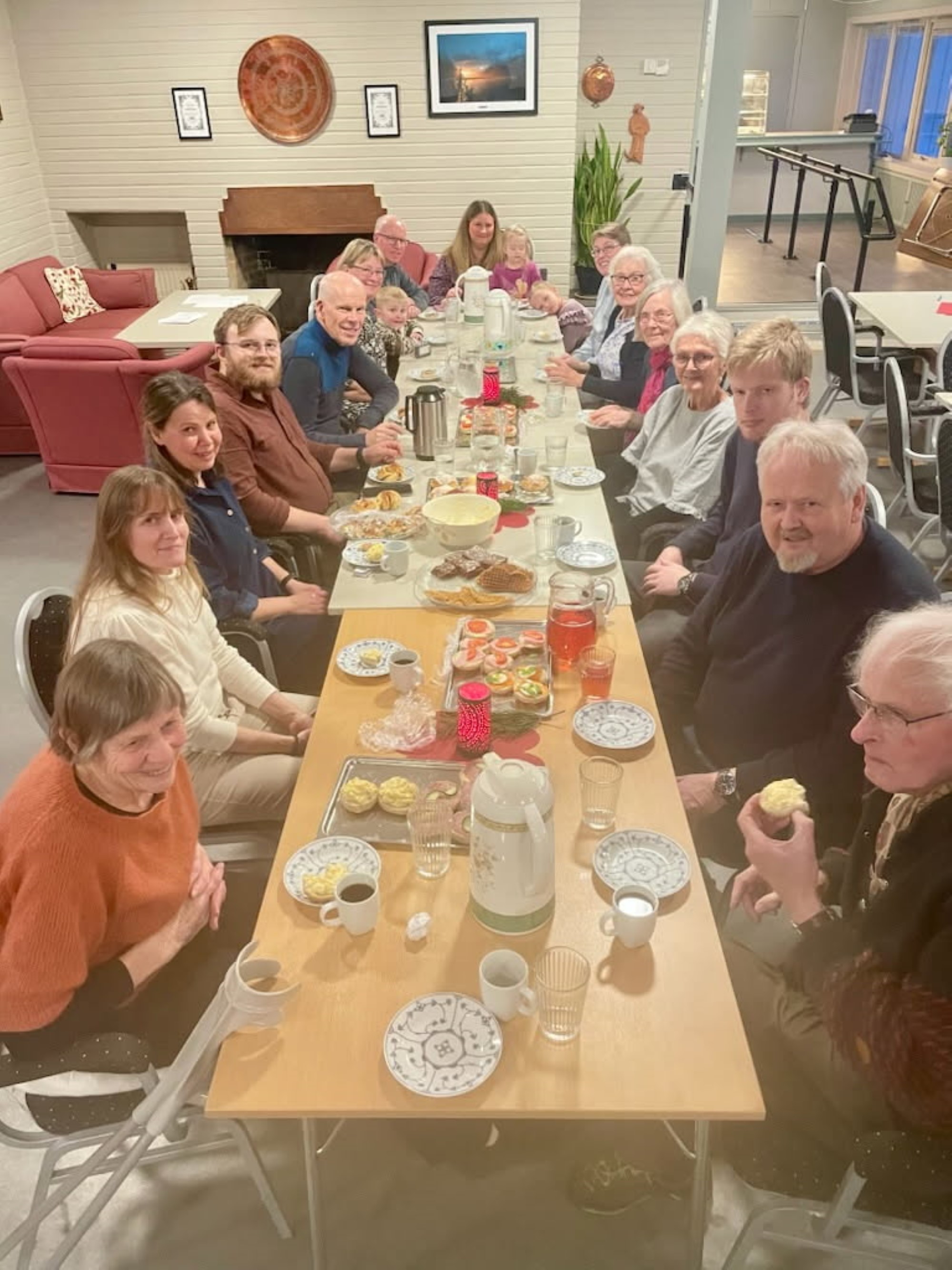 Bildet visermange mennesker som sitter rundt et bord