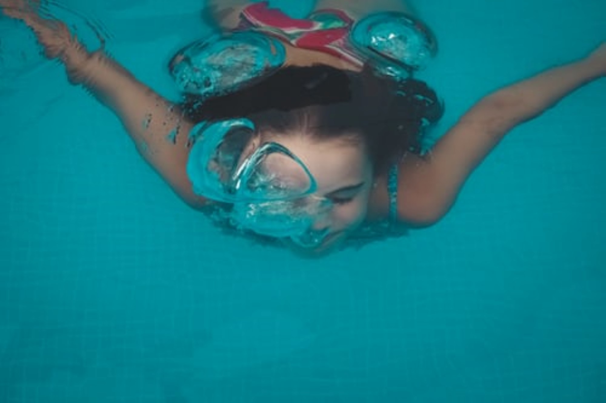 Jente som dykker i basseng