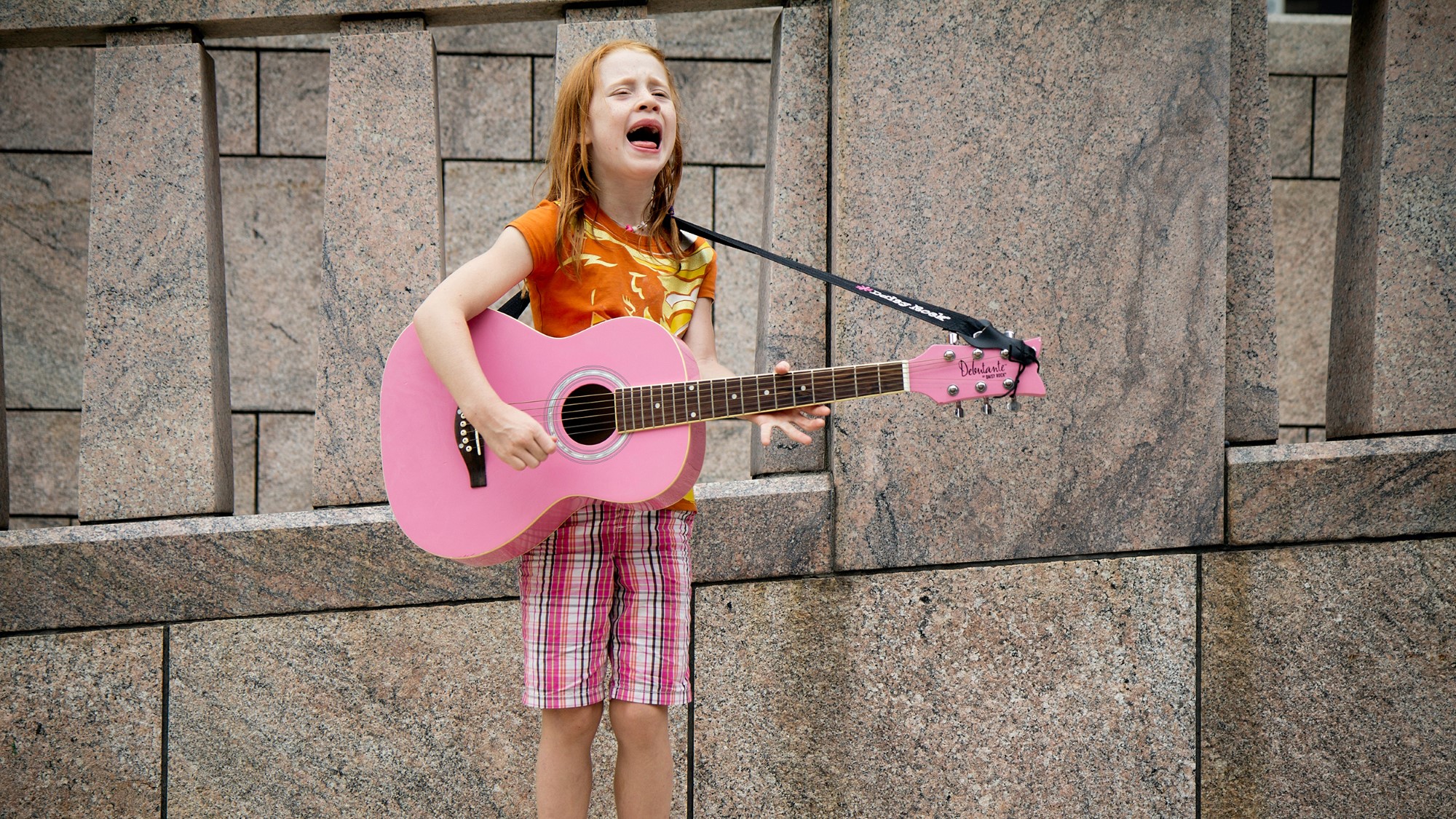 Jente med rosa gitar synger inderlig
