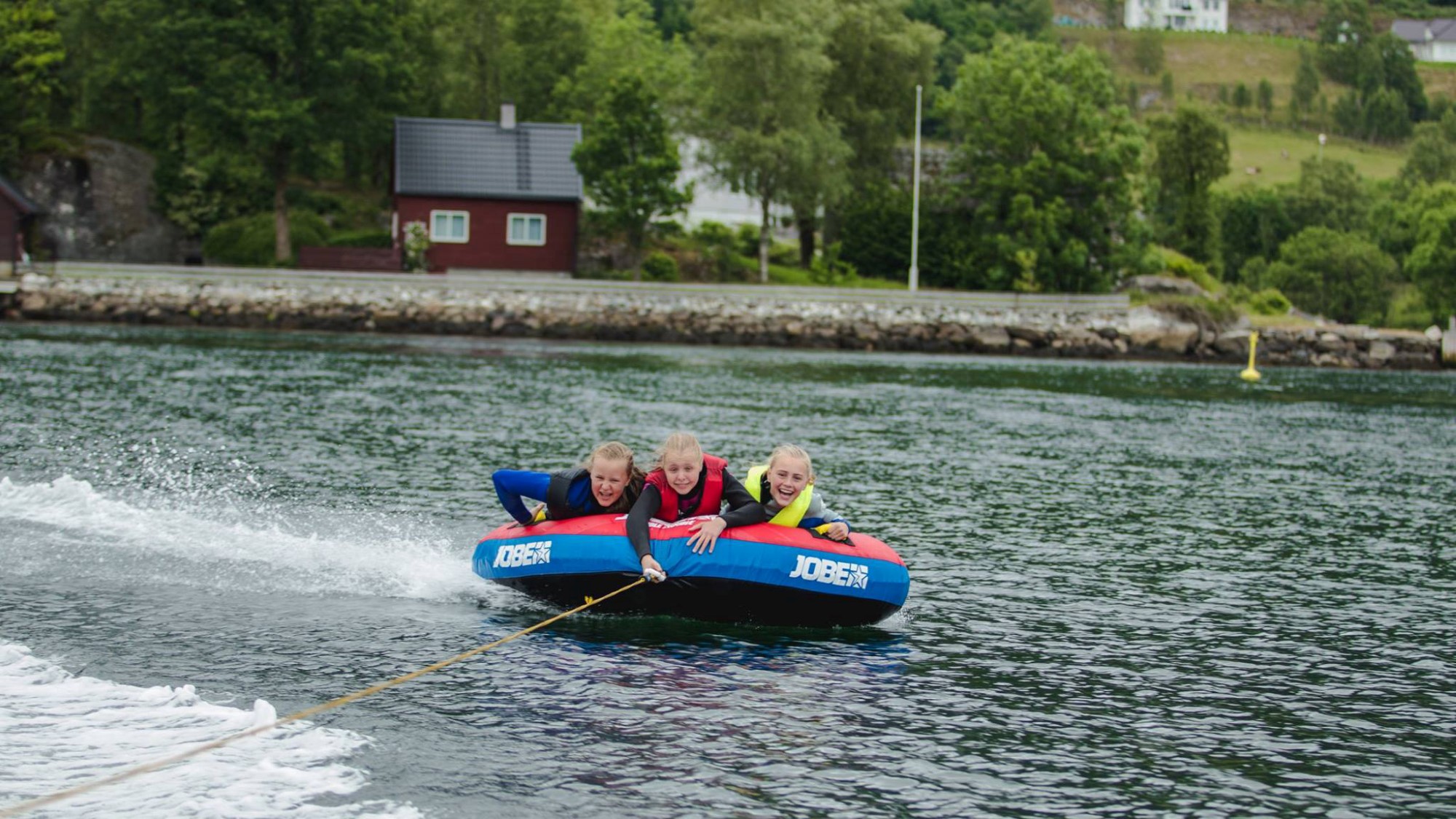 Jenter trekkes bak båt
