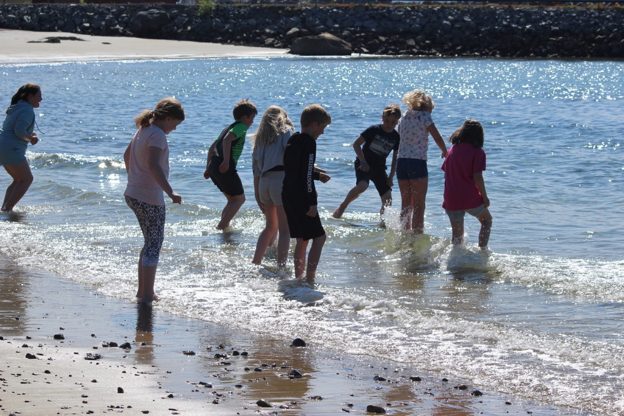 Bildet viser mange barn som bader på en strand
