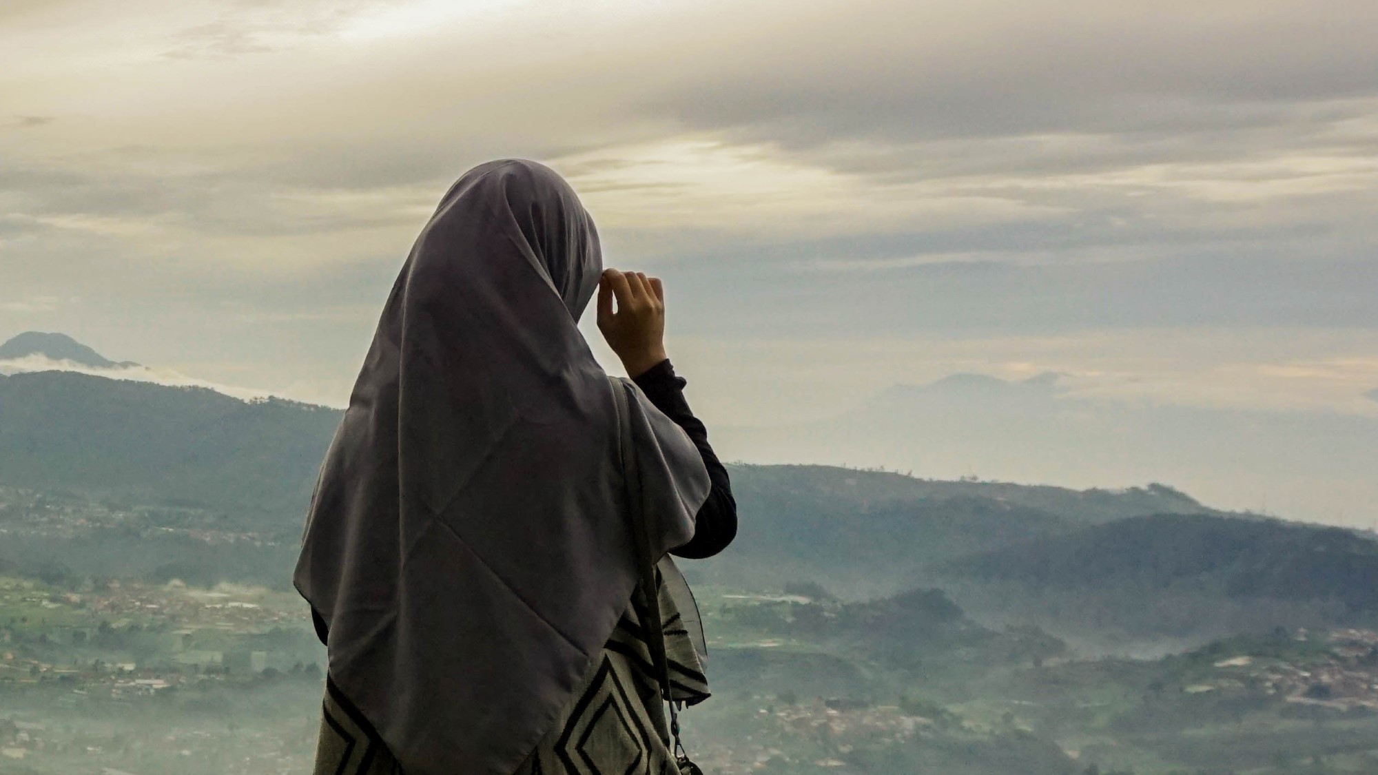 Muslimsk kvinne ser utover landskap