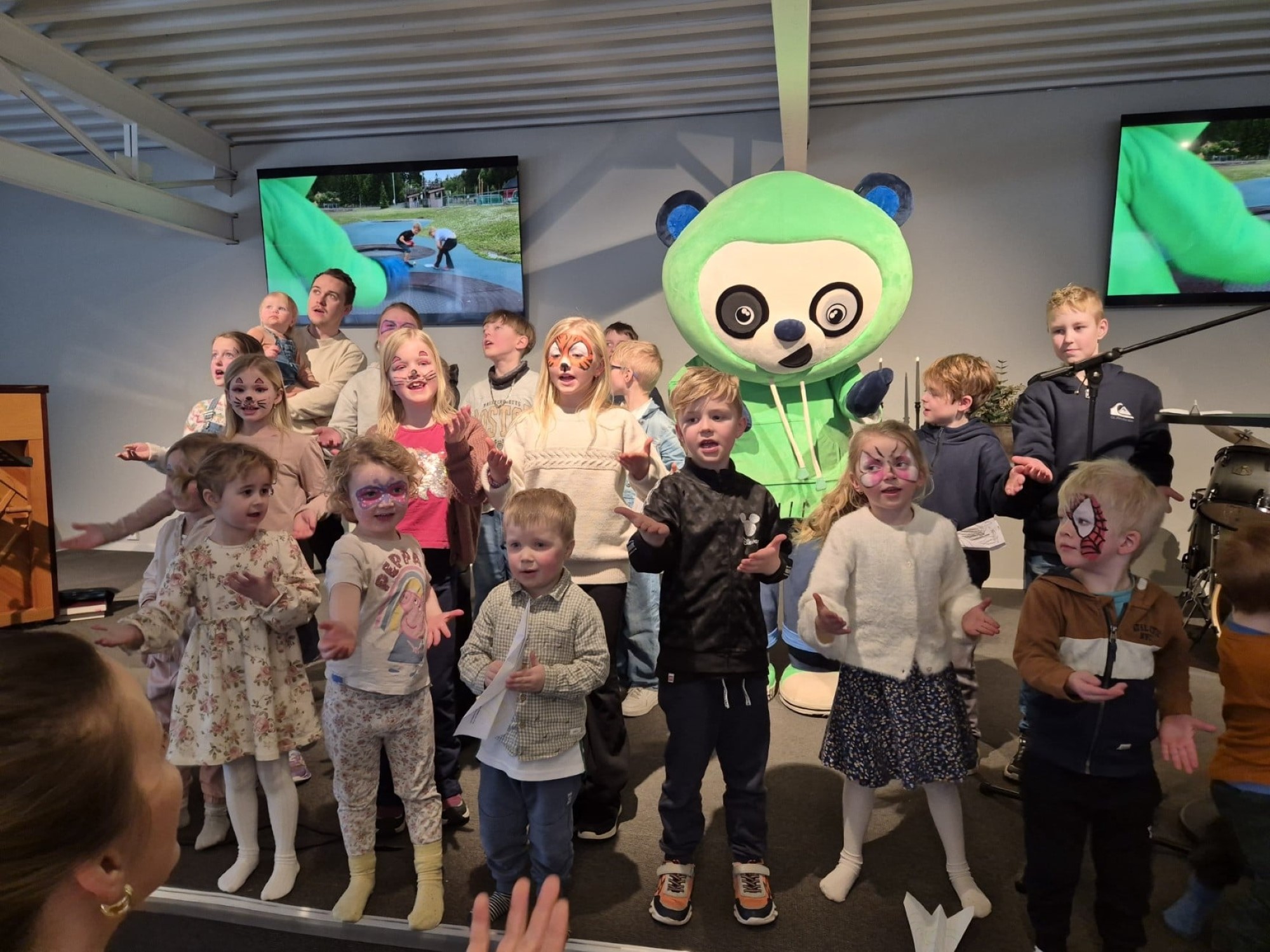 Bildet viser mange barn som står å synger