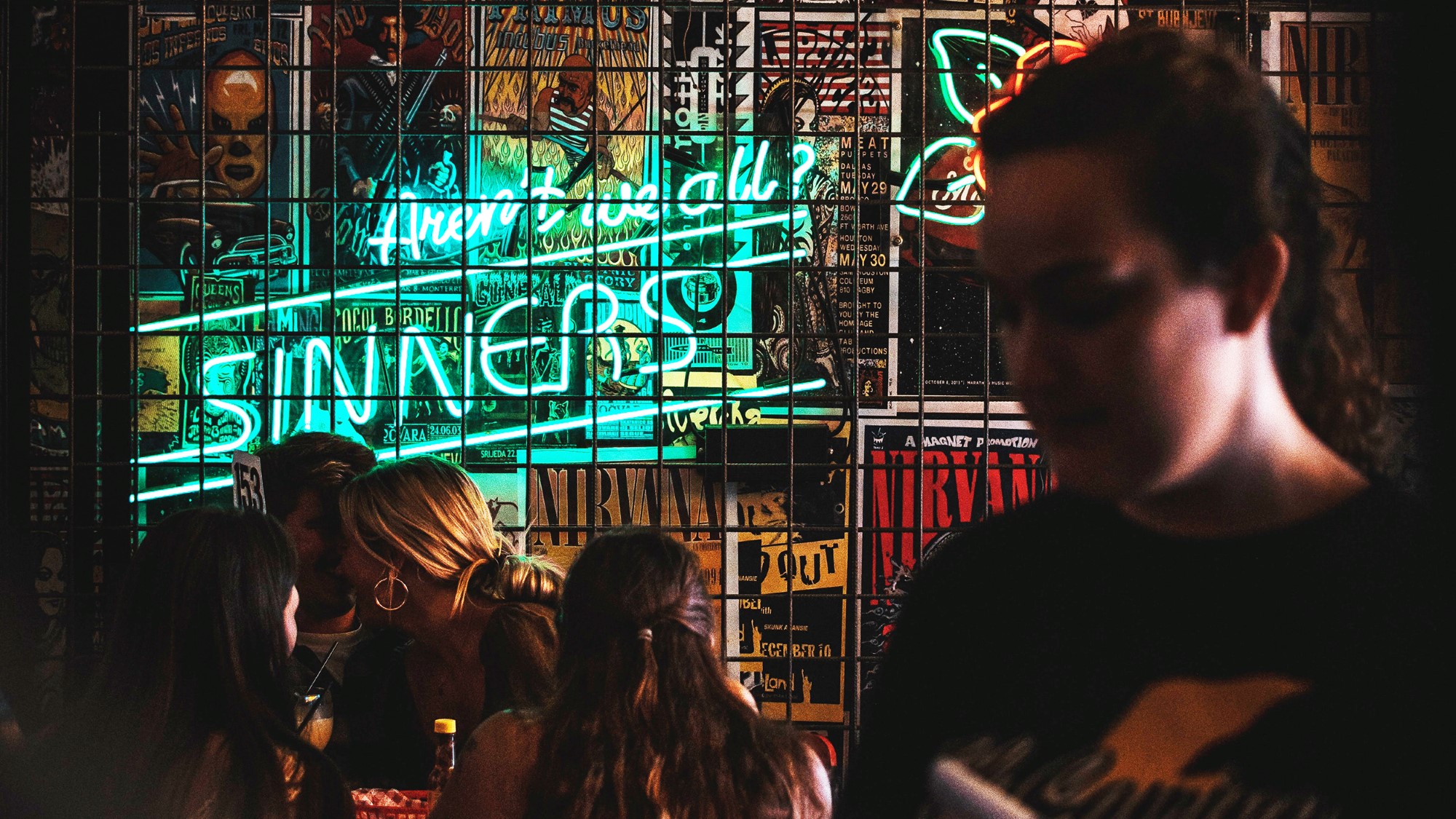 Cafélokale med neonskilt "aren't we all sinners?"