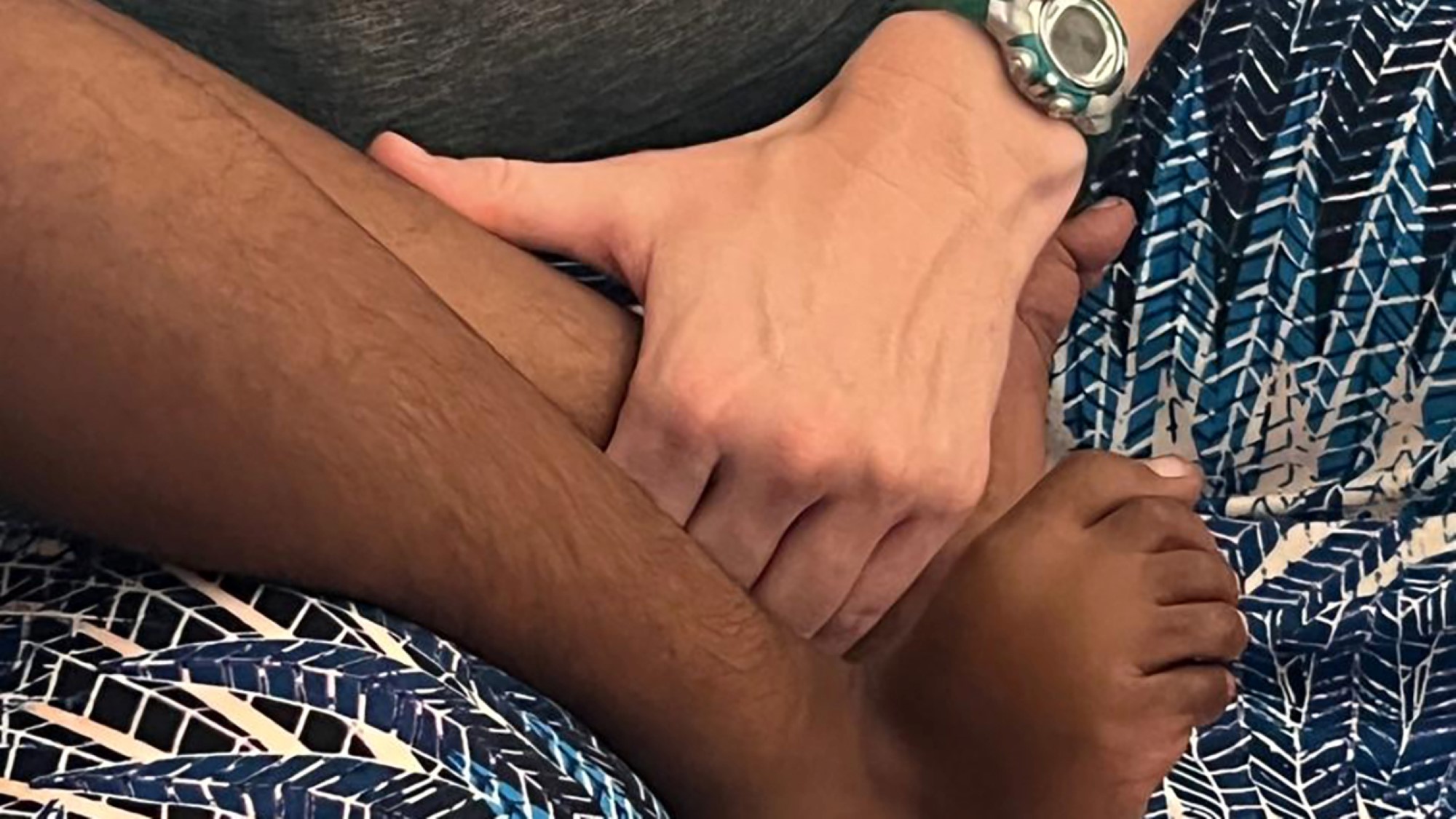 Hender holder rundt barneføtter