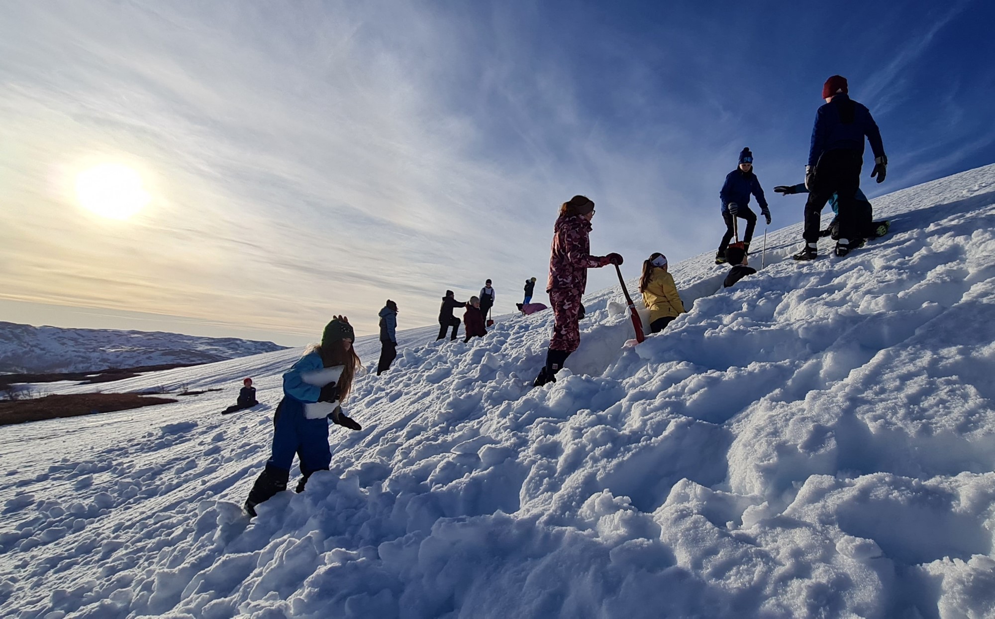 Ungdommer graver i snø på fjellet