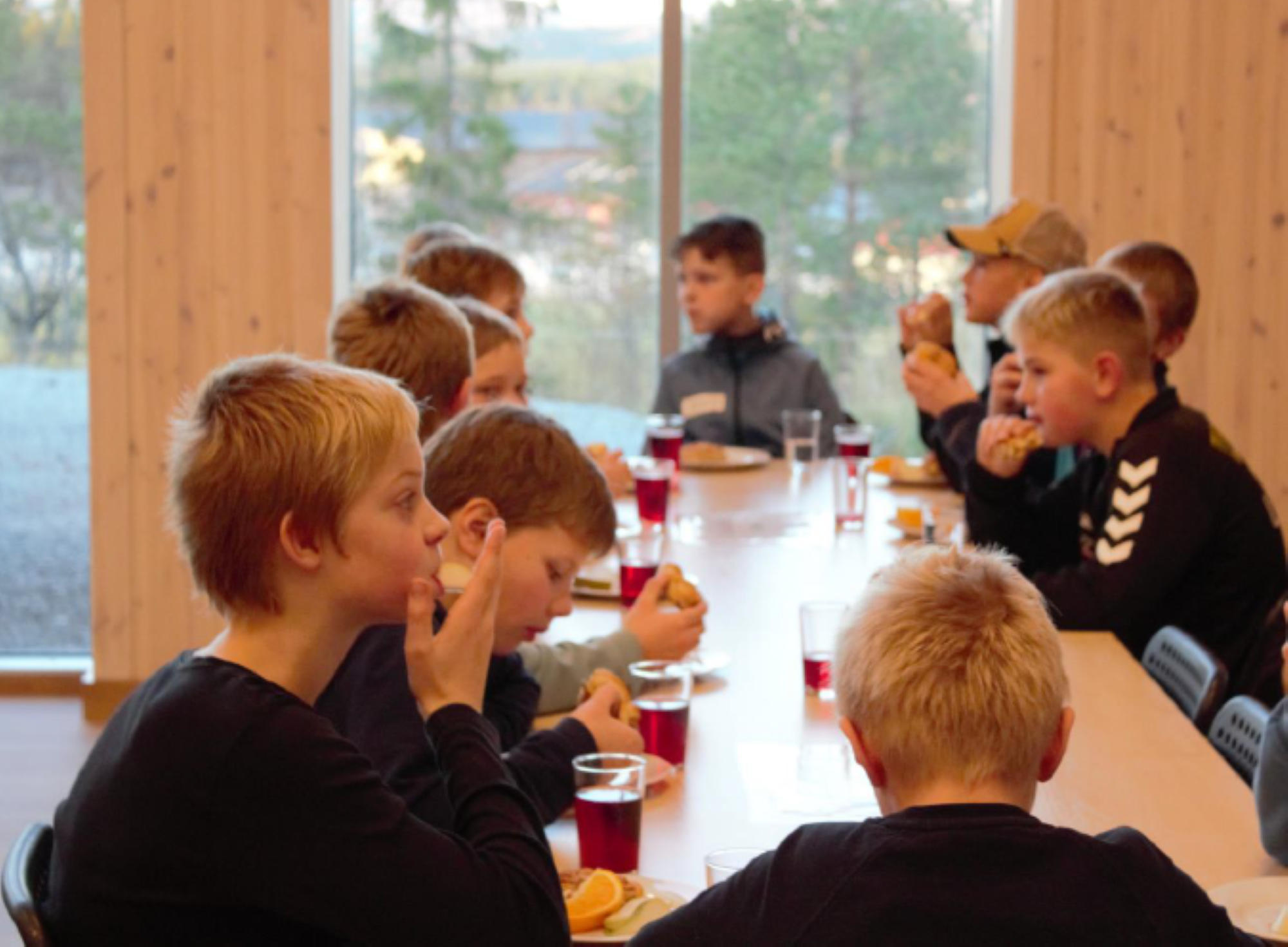 Leirgutter spiser rundt et bord