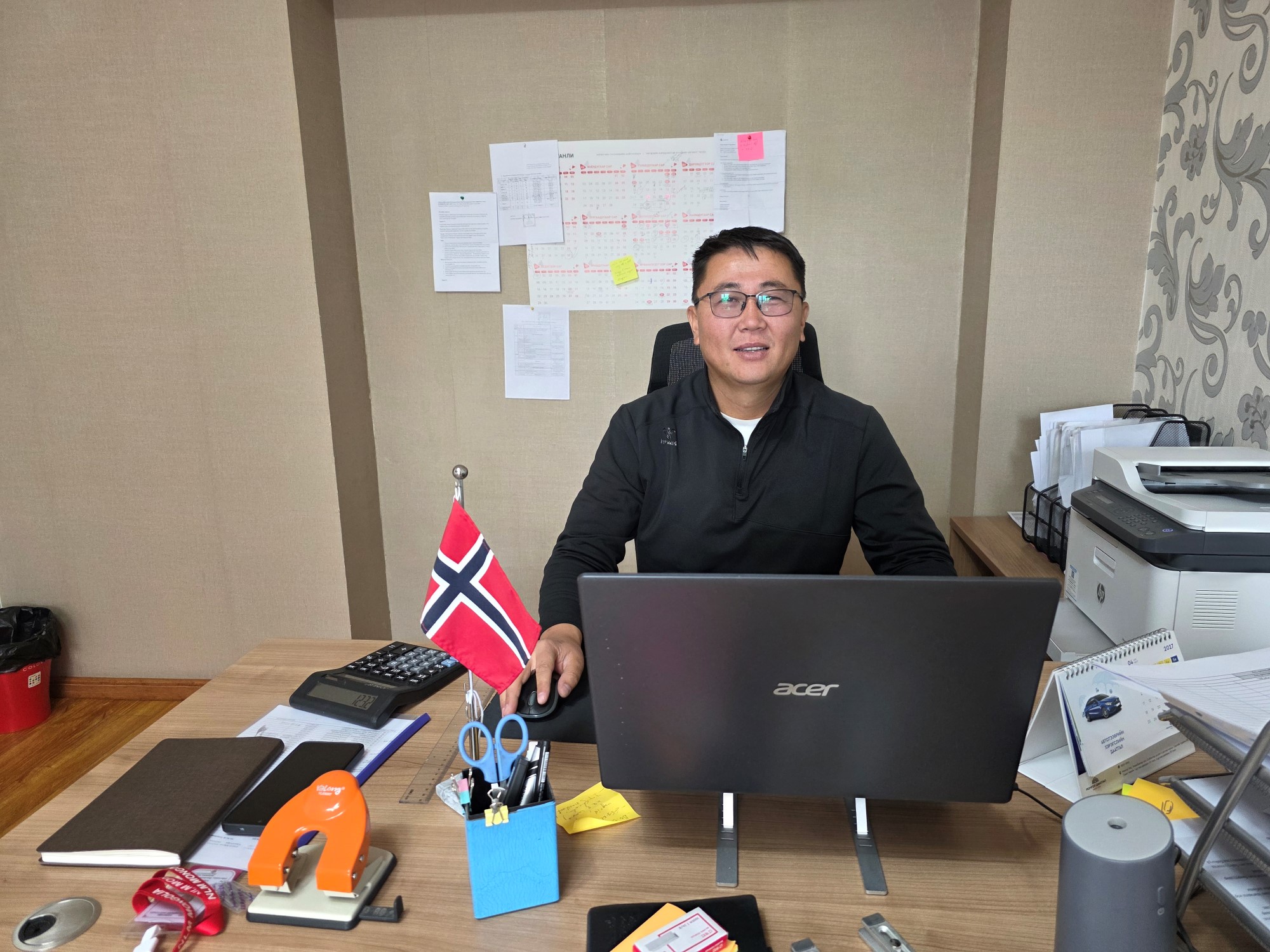 Bauyrjan som sitter ved pulten sitt på kontoret