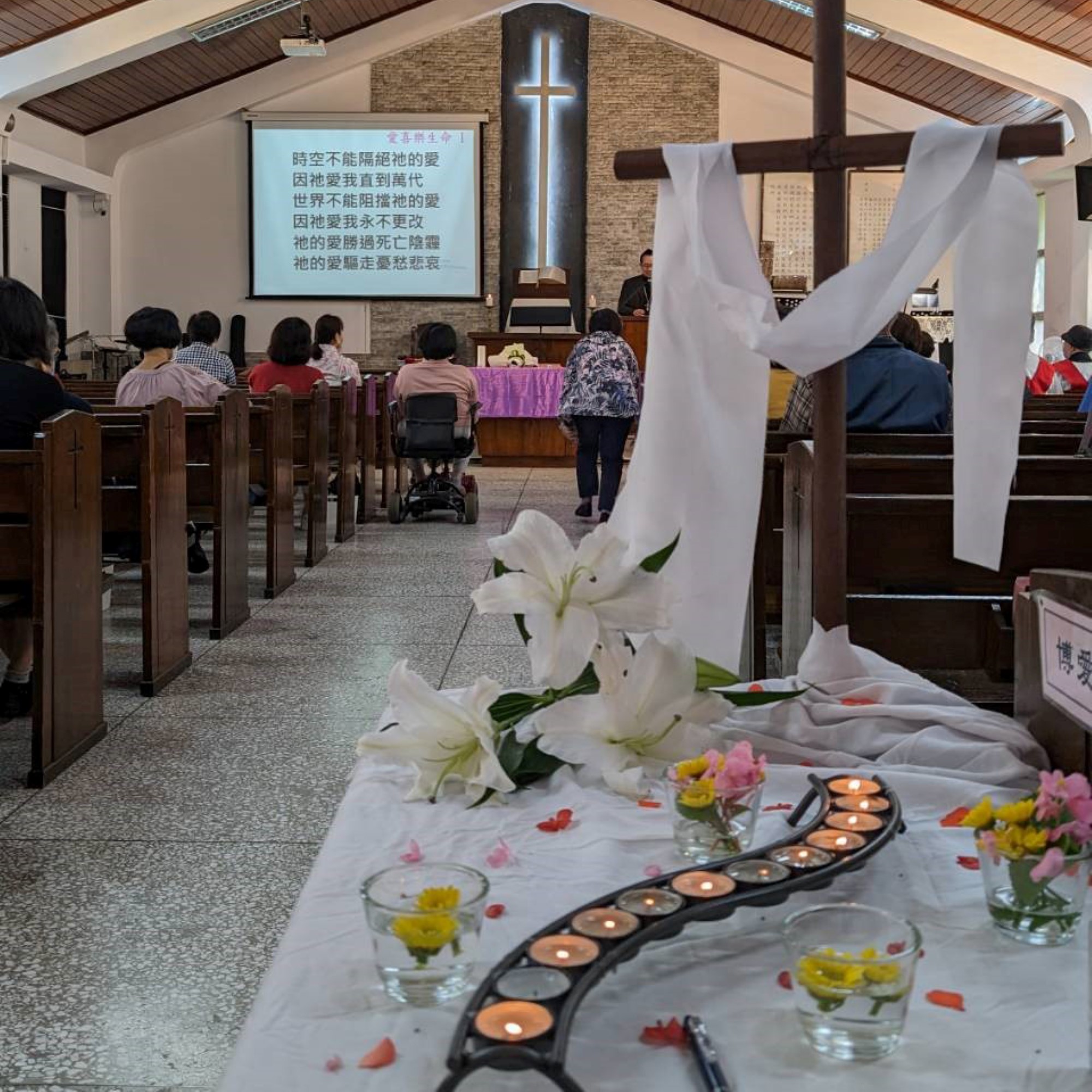 Kirkerommet pyntet med lys, blomster og kors