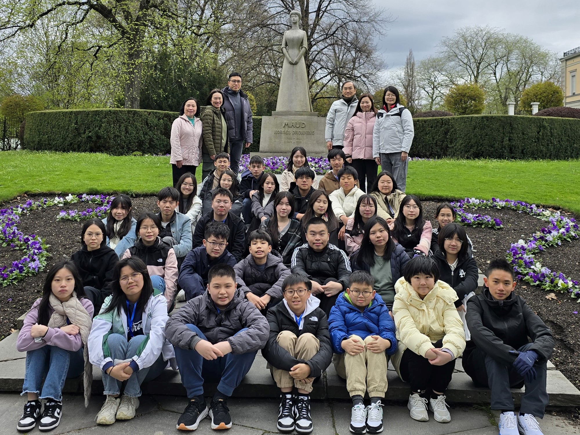 Gjengen fra Hongkong foran statuen av dronning Maud