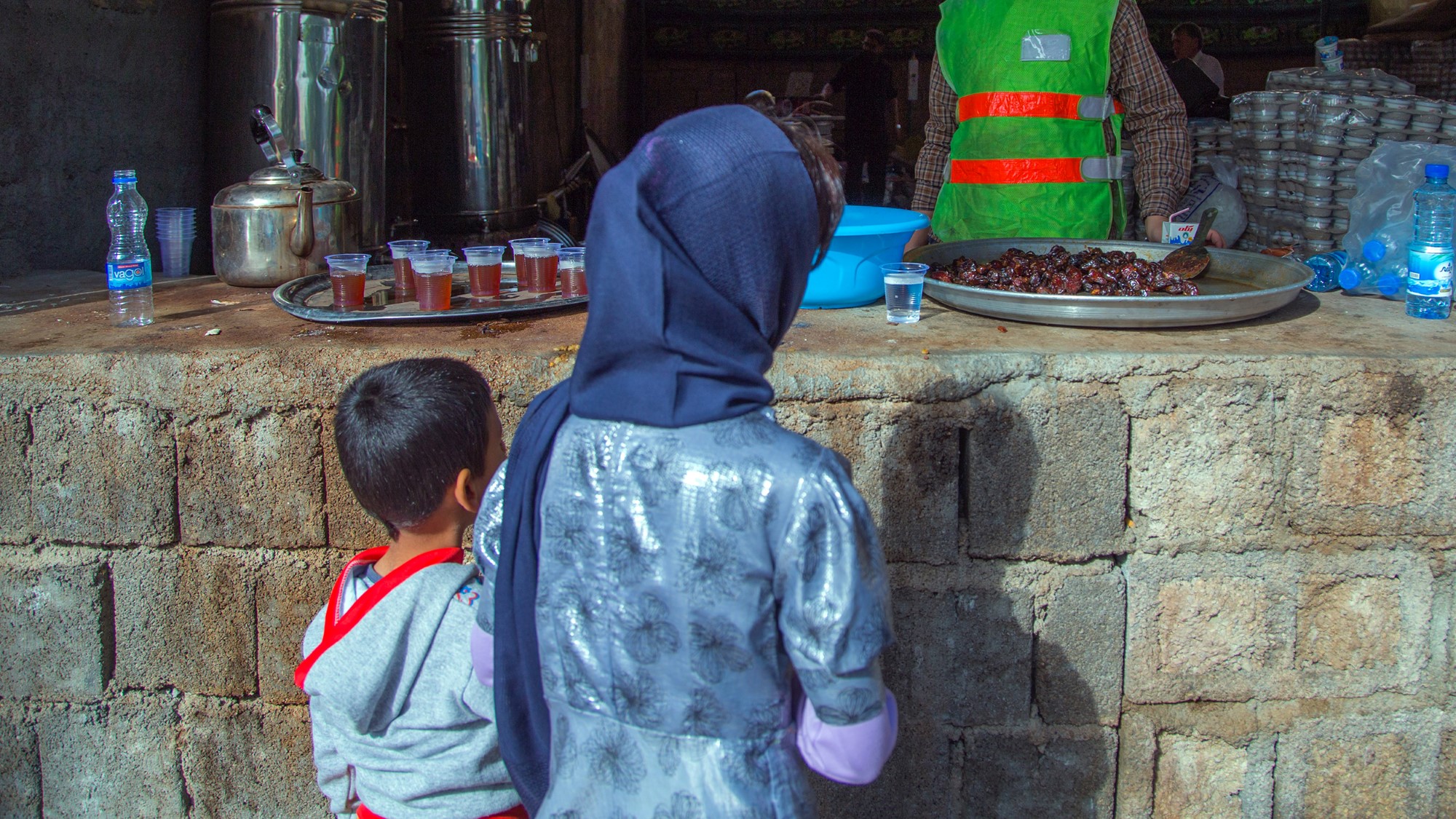 Muslimsk kvinne med barn mottar mat