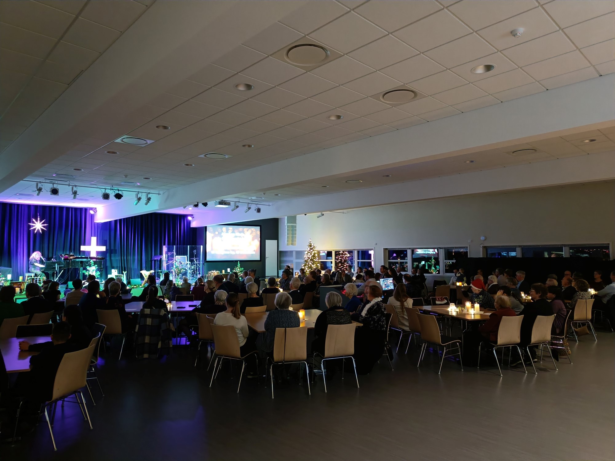 Bildet viser smilende mennesker som sitter rundt et bord