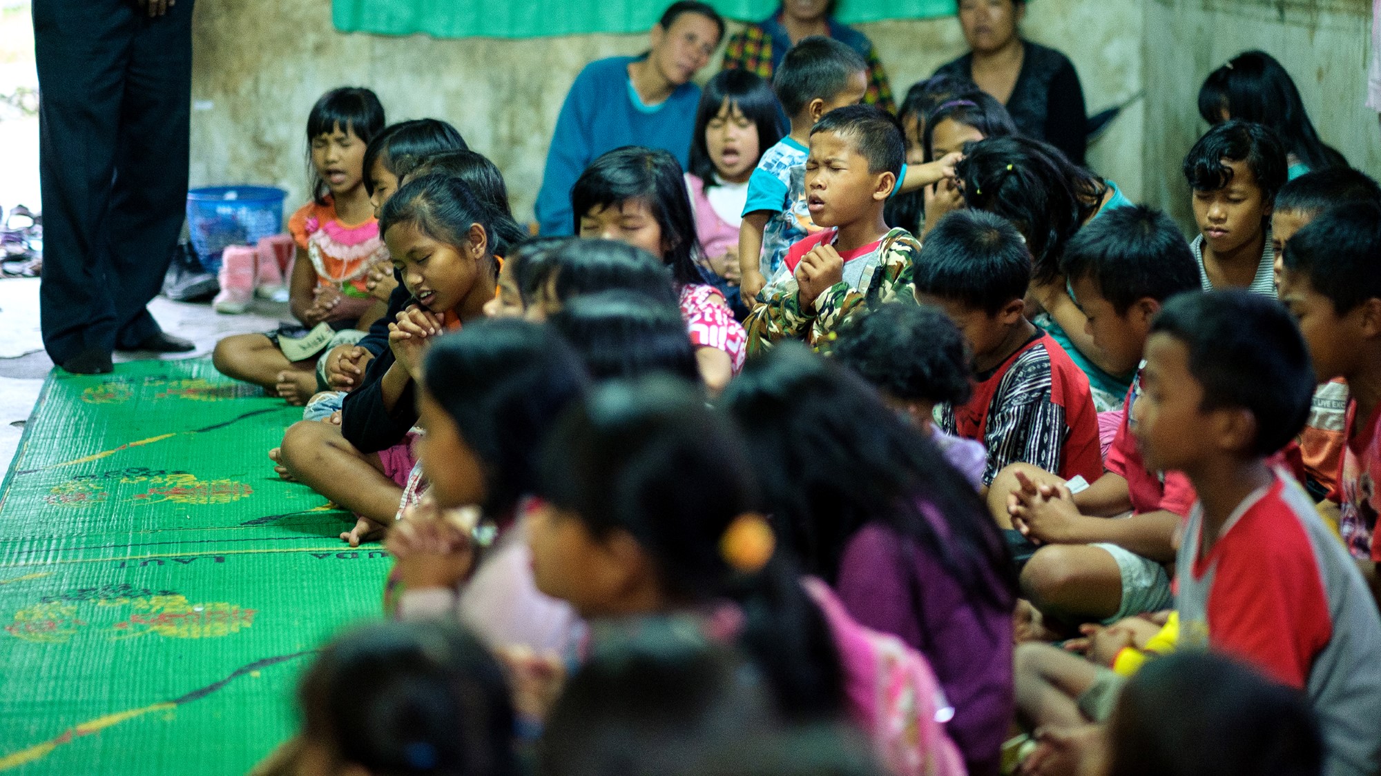 Indonesiske barn ber sammen