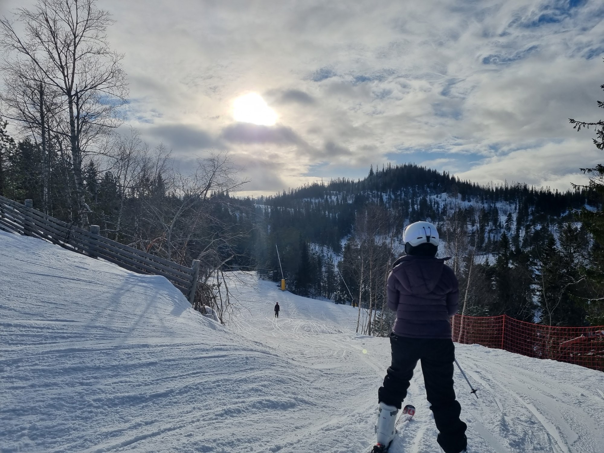 Jente står på ski i slalombakke