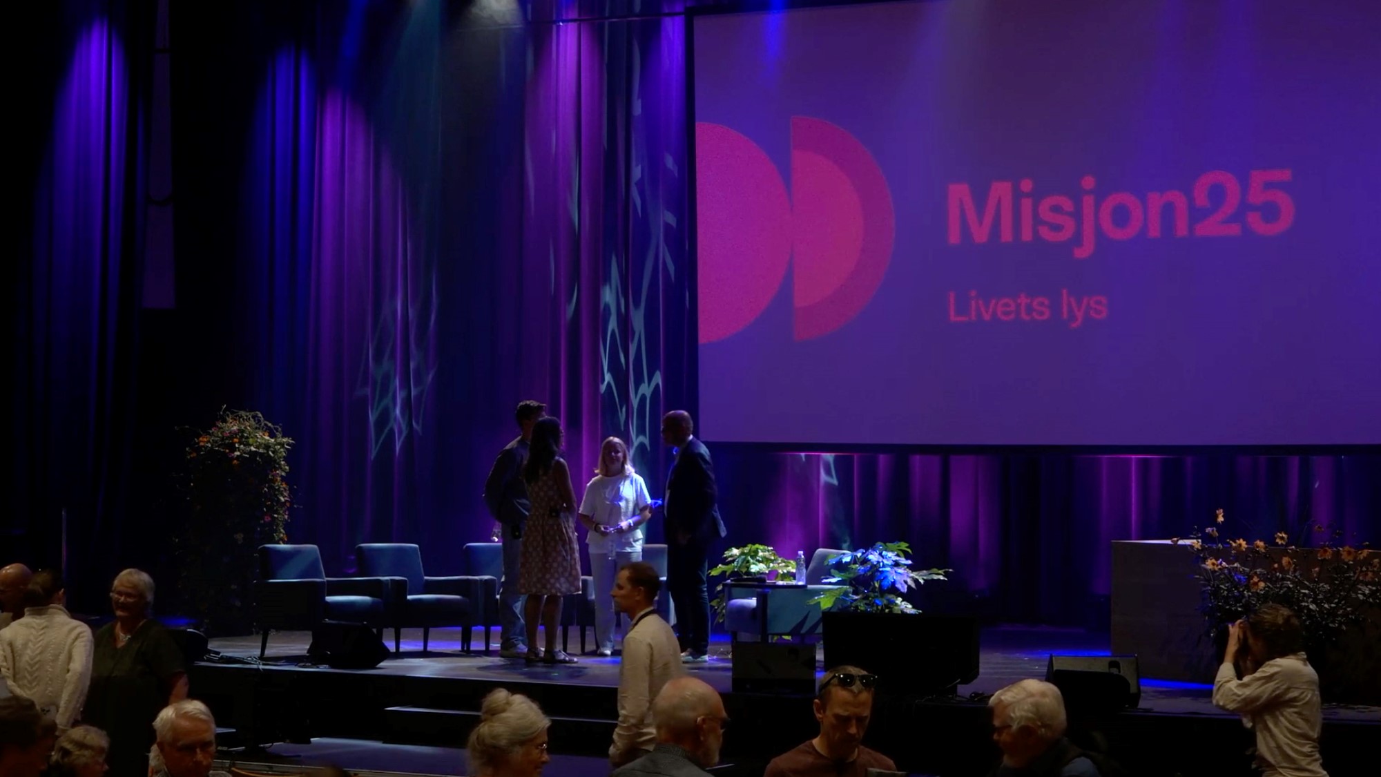 Stillbilde av scenen hvor podkasten ble spilt inn. Noen av deltakerne prater sammen før sending.