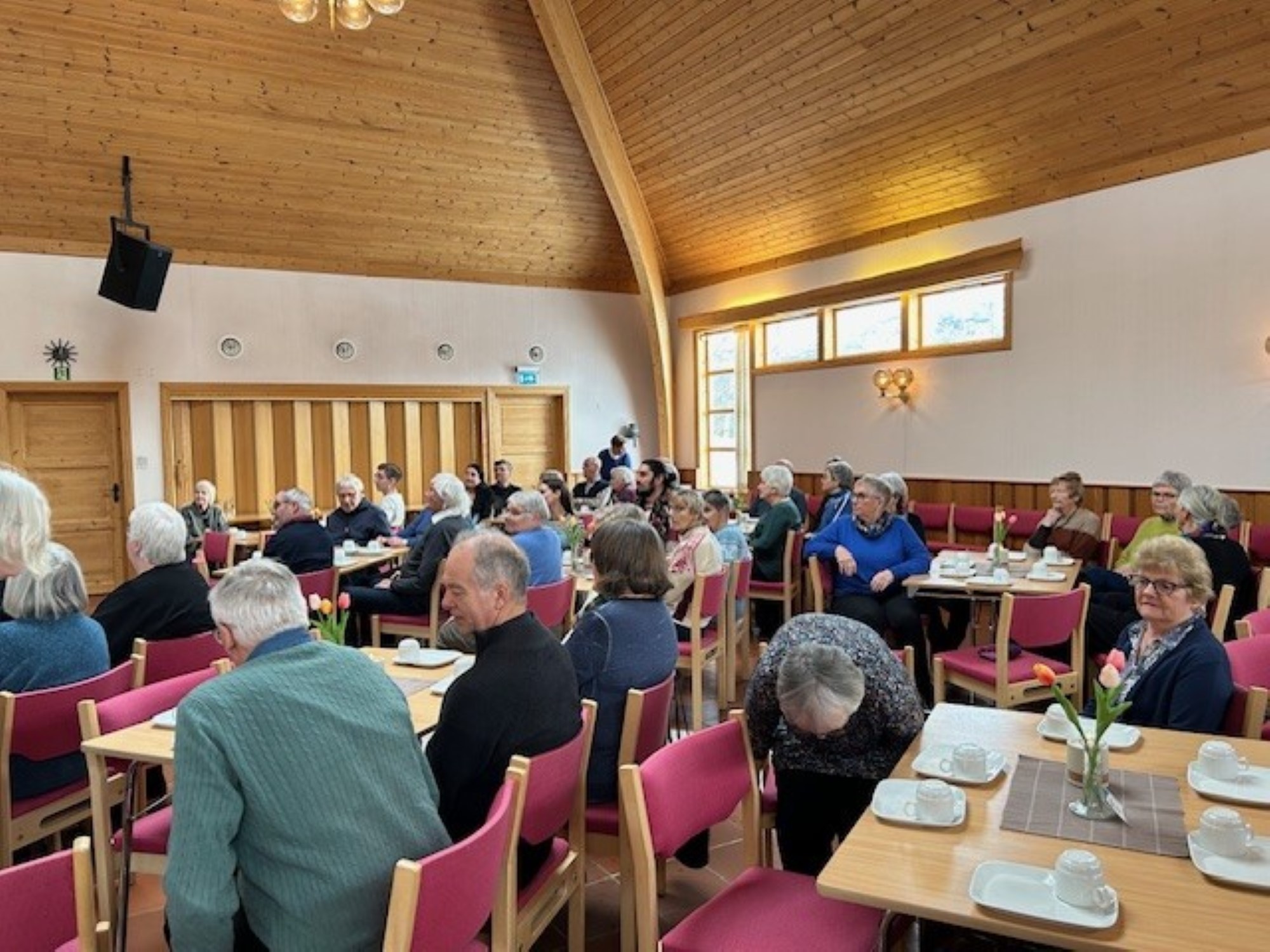 Møtesal med mennesker samlet rundt kaffebord