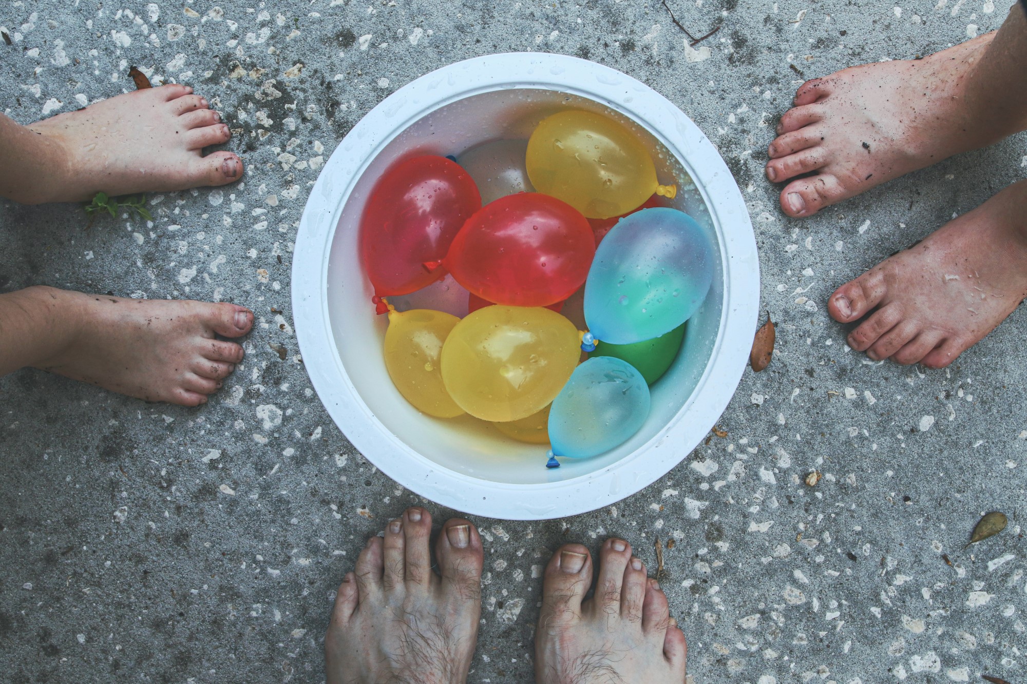 vannballonger i bøtte, bare føtter rundt.