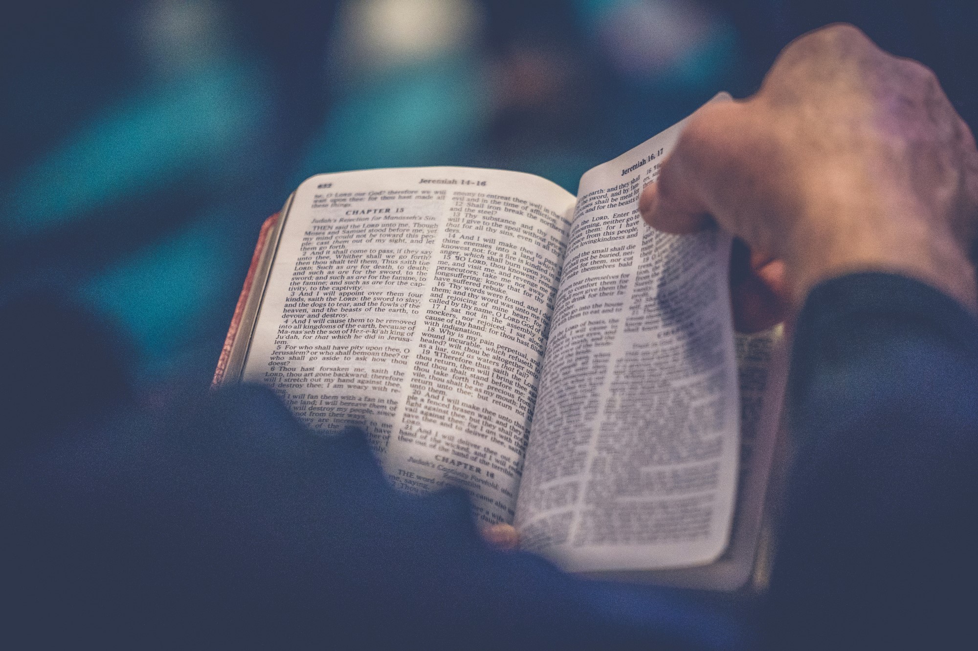 Hender som blar i en åpen bibel