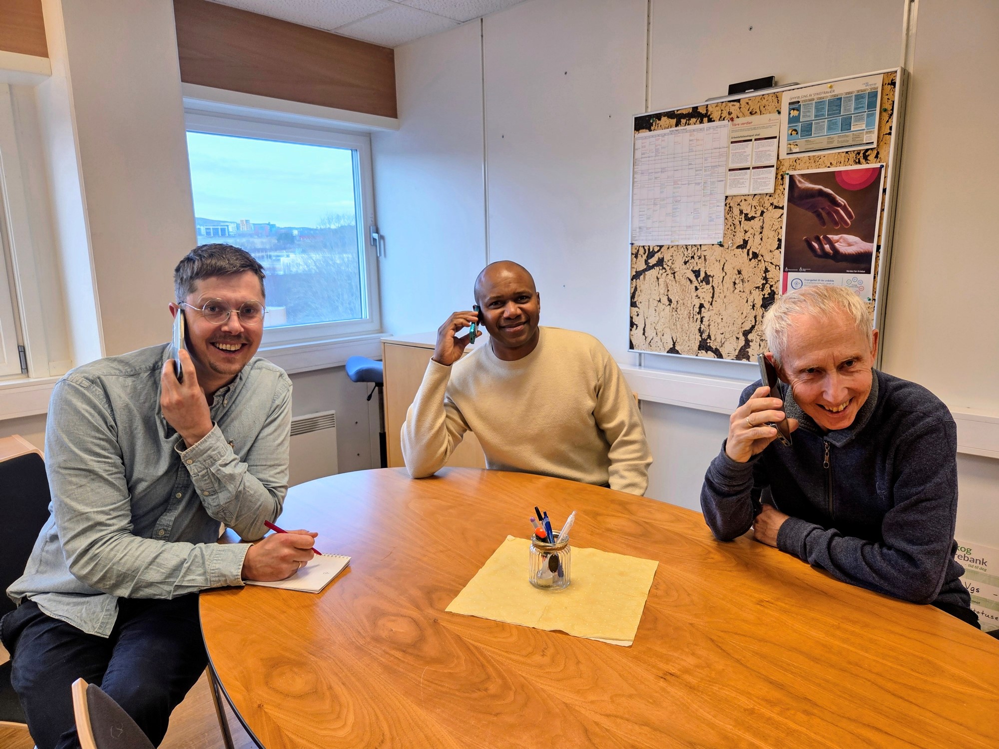 Bildet viser 3 menn som snakker i telefon