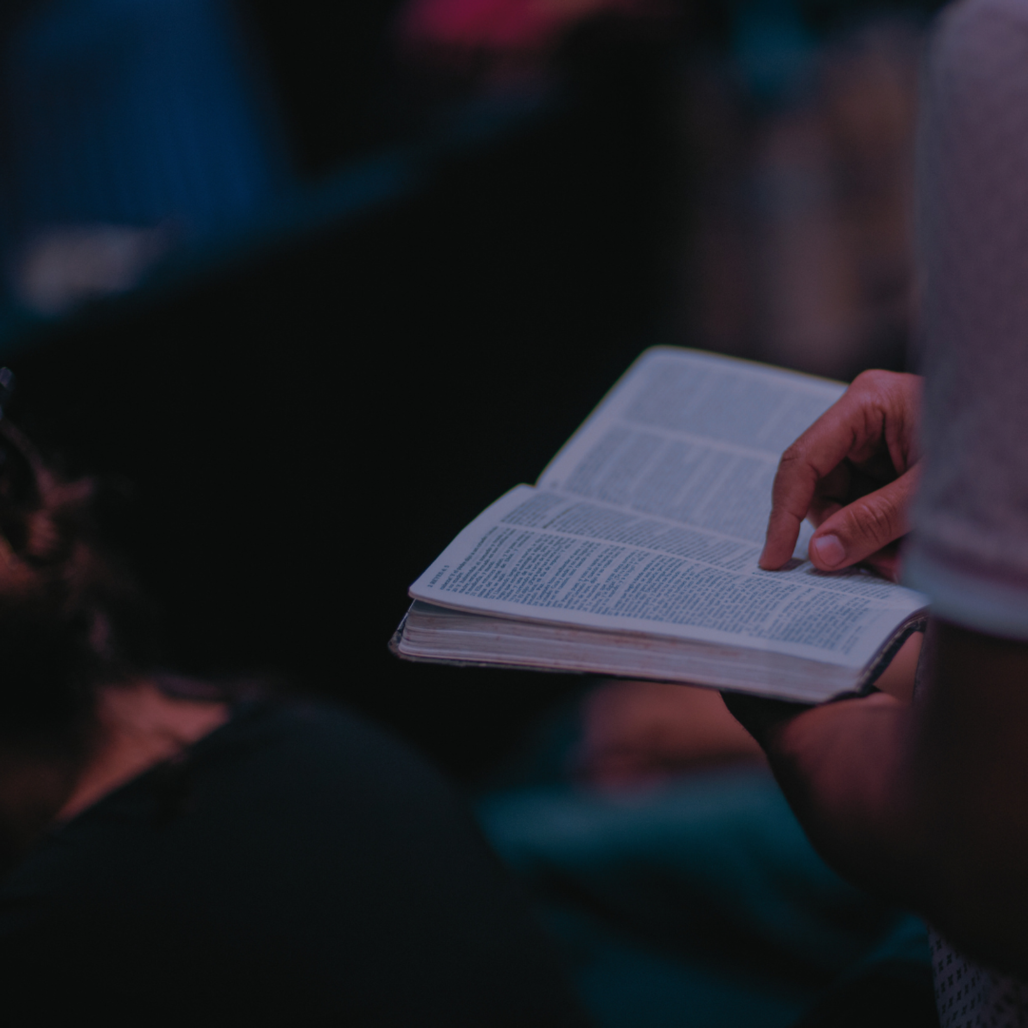 Bildet viser noen hender som holder en åpen bibel