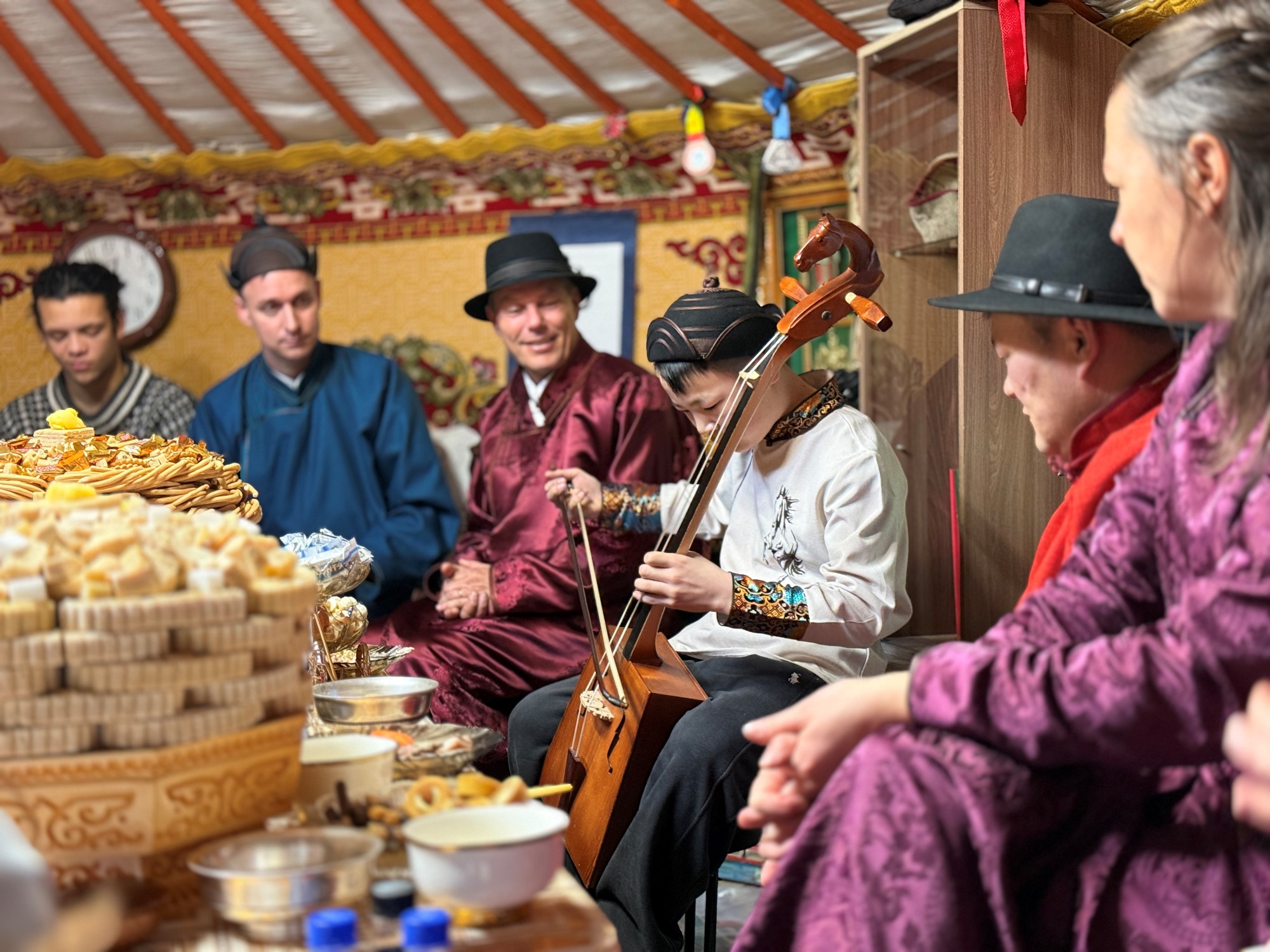 Besøk hjå lokal familie. Eit av borna speler på hestefele
