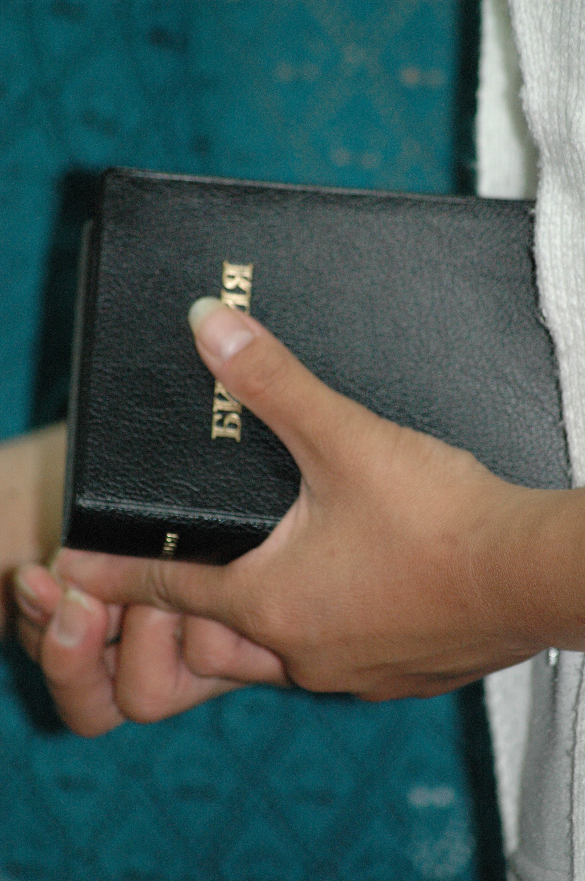 Sentral-asiatisk kvinne som holder en bibel