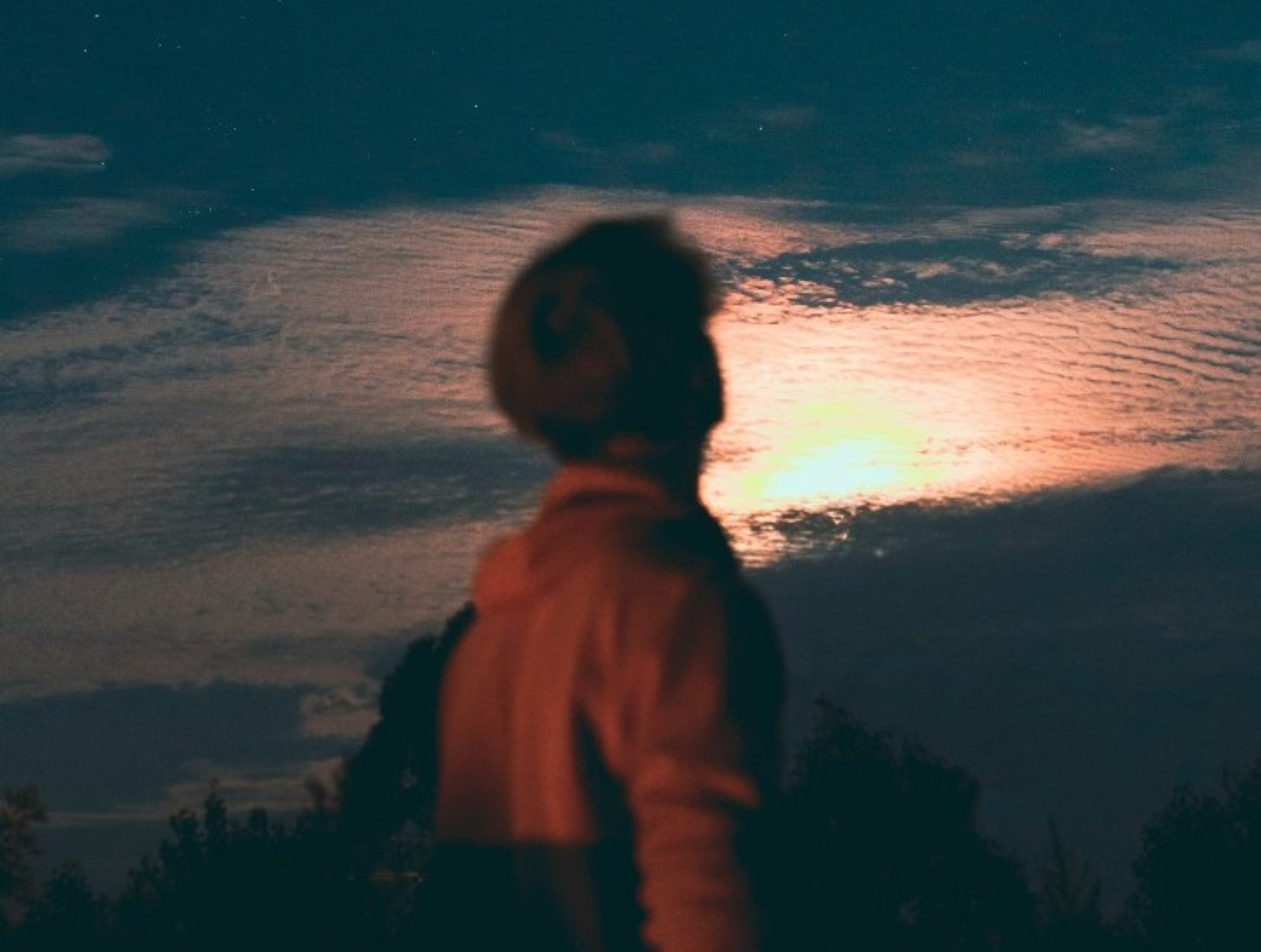 Mann ser opp mot solnedgang