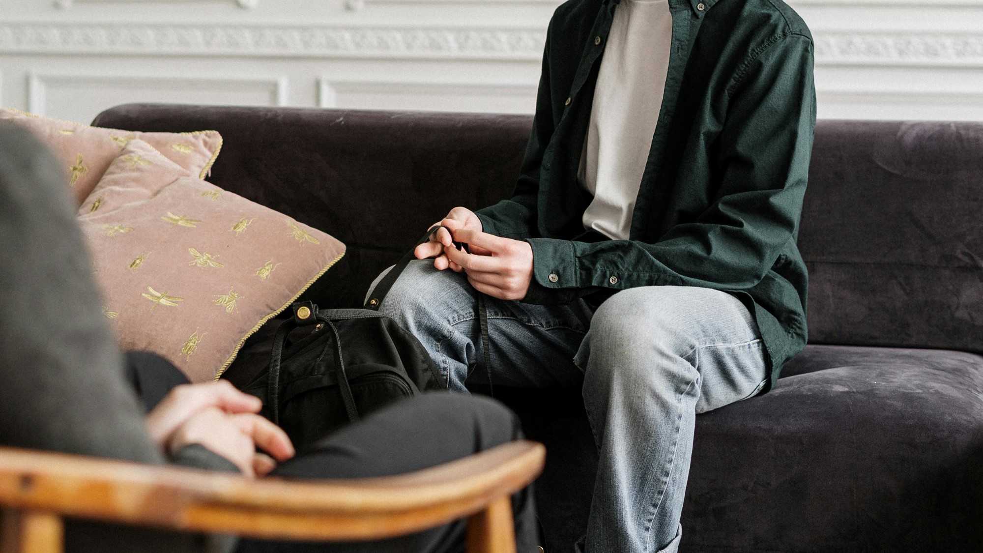 Ung mann sitter og samtaler med person