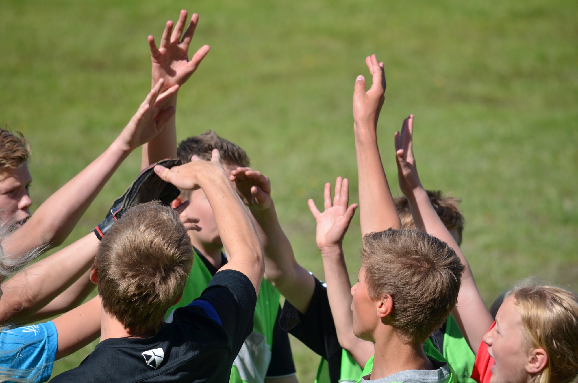Ungdommer tar en hig five på fotballbanen
