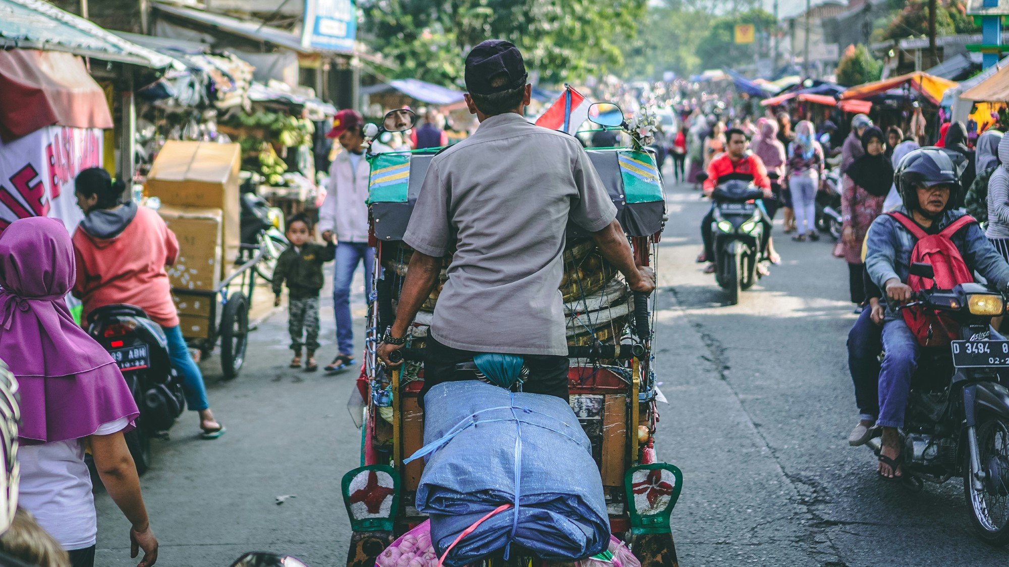 Folk og motorsykkel i indonesisk gateliv