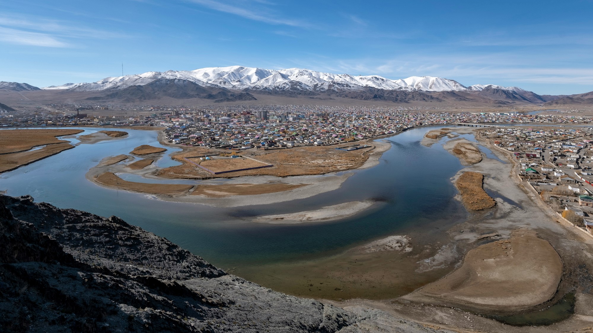 Mongolsk slettelandskap med elv og by