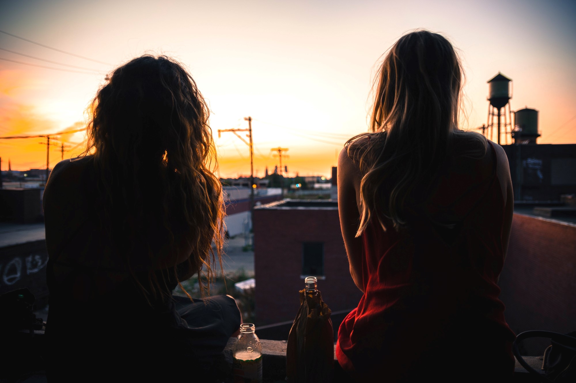 To jenter bakfra i solnedgang